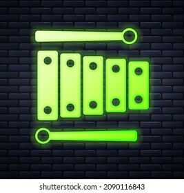 Glowing neon Xylophone - musical instrument with thirteen wooden bars and two percussion mallets icon isolated on brick wall background.  Vector