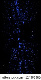 Glowing particles, polka dots on a dark blue background. Vertical festive banner. An elegant holiday pattern. Vector illustration.