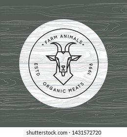 A goat is drawn in a linear style for a farm logo on a background of vector wood texture. Organic meat or farming animal - vector logo made in a linear style.