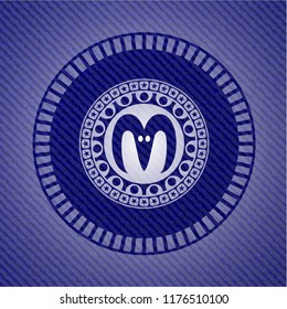 goat head icon inside emblem with denim texture
