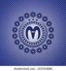 goat head icon inside emblem with denim texture