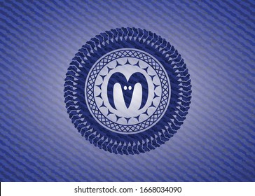 icono de cabeza de cabra dentro del emblema con textura de denim