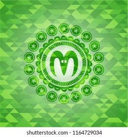 goat head icon inside green emblem with triangle mosaic background