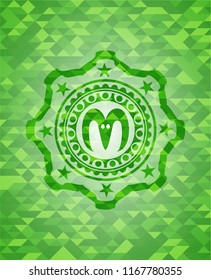 goat head icon inside green emblem with mosaic ecological style background