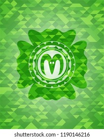 goat head icon inside green emblem with mosaic ecological style background