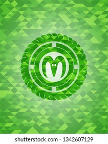 goat head icon inside green mosaic emblem