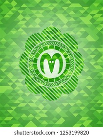 goat head icon inside realistic green emblem. Mosaic background