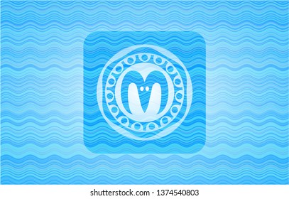 goat head icon inside water wave style badge.