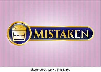  Gold badge or emblem with popcorn icon and Mistaken text inside