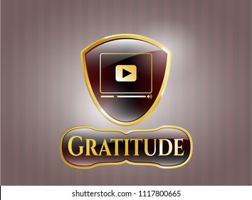  Gold badge or emblem with video player icon and Gratitude text inside