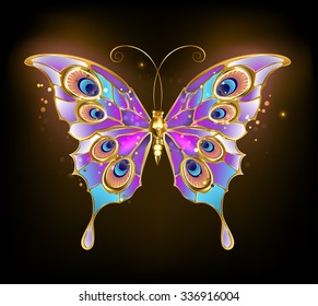 Gold butterfly with wings patterned peacock on dark background.