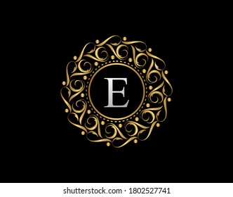 Insignia caligráfica de oro con diseño de letra E. Dibujo vectorial del diseño del logotipo dorado de lujo ornamental.