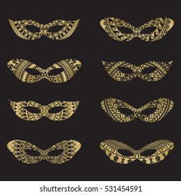 Gold color masquerade mask silhouettes with decorative elements on black background