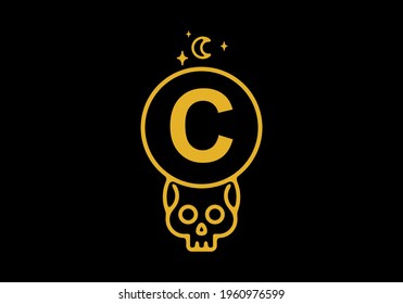 Gold color on dark background of C initial letter in skull circle