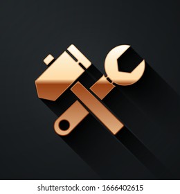 Gold Crossed hammer and wrench spanner icon isolated on black background. Hardware tools. Long shadow style. Vector Illustration