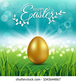 Gold egg on fresh spring grass with text for Easter day greeting card