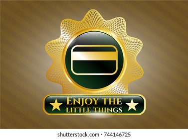  Gold emblem or badge with credit card icon and Enjoy the little things text inside