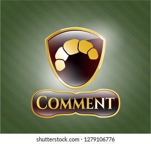  Gold emblem or badge with croissant icon and Comment text inside