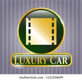  Gold emblem or badge with film icon and Luxury Car text inside