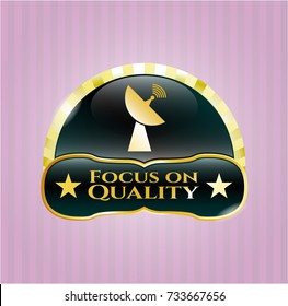  Gold emblem or badge with radar icon and Focus on Quality text inside