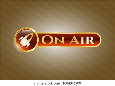   Gold emblem with rocket icon and On Air text inside