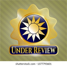  Gold emblem with sun icon and Under Review text inside