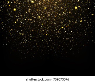 Gold glitter particles sparkles on black background.