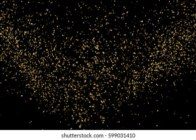 Gold glitter texture isolated on black. Amber particles color. Celebratory background. Golden explosion of confetti. 