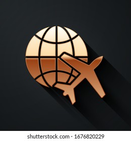 Gold Globe with flying plane icon isolated on black background. Airplane fly around the planet earth. Aircraft world icon. Long shadow style. Vector Illustration