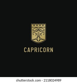 Gold goat vector logo in line art style with crowned shield shape. This is the zodiac sign Capricorn.