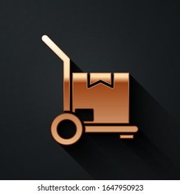 Gold Hand truck and boxes icon isolated on black background. Dolly symbol. Long shadow style. Vector Illustration
