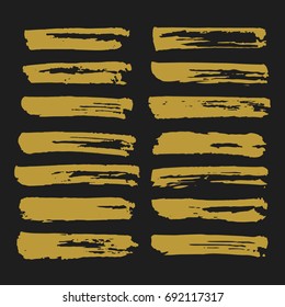 Gold ink brush strokes set. Trendy hand drawn brush strokes. Vector brushstrokes isolated on black background