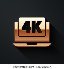 Gold Laptop screen with 4k video technology icon isolated on black background. Long shadow style. Vector Illustration