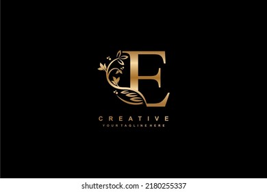 diseño del logo de la letra dorada E con decoración de flores, hojas y plumas en un estilo hermoso y elegante. monograma E. tipografía E. logotipo de las iniciales E. adecuado para negocios, bodas, boutique, empresa, etc