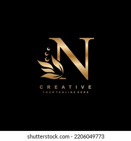 gold letter N logo design with flourish ornaments. logo N with floral and leaf ornaments. N beautiful logo. luxury letter N logo design