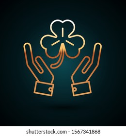Gold line Human hands holding four leaf clover icon isolated on dark blue background. Happy Saint Patrick day.  Vector Illustration