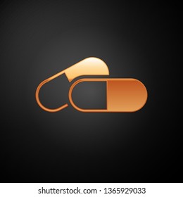 Gold Medicine pill or tablet icon isolated on black background. Capsule pill and drug sign. Pharmacy design. Vector Illustration