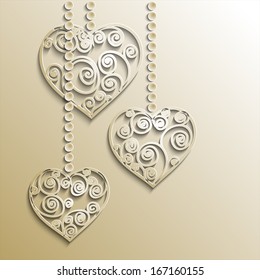 Gold openwork hearts on chains on gold background 
