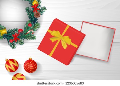 gold ribbon and gift box is open on the top of white wooden table with christmas wreath. concept design of surprised present gift in Christmas or new year in vector. it also use for marketing and sale