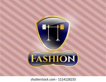   Gold shiny badge with barbell on rack icon and Fashion text inside