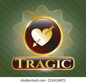 Gold shiny badge with heart with arrow icon and Tragic text inside