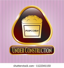  Gold shiny emblem with popcorn icon and Under Construction text inside