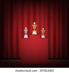 Gold silver bronze trophy on a stage with red curtain backgrond