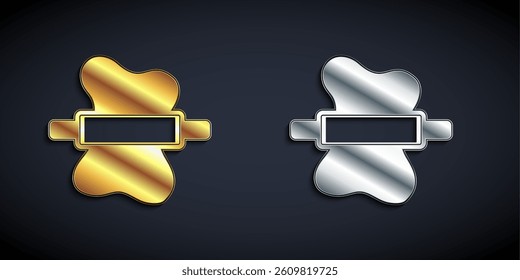 Gold and silver Rolling pin on dough icon isolated on black background. Long shadow style. Vector