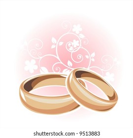 Gold wedding rings and floral pattern on a white background.
