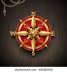 Golden ancient compass rose on a wooden plank background. Vector illustration.