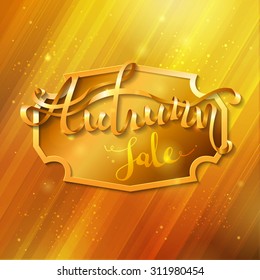 Golden autumn background. Golden badge in the center and golden words "Autumn sale" on it. Word "Autumn" is written from ribbon.