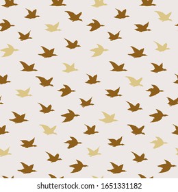 Golden Beige Swallow Birds Print. Seamless Pattern with Modern Inky Birds Silhouettes for fabrics textile print design, wallpapers. Elegant flying crabe birds isolated on light background