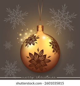 A golden Christmas sphere with a brown flower pattern set against a festive background.