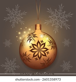 A golden Christmas sphere with a flower pattern set against a background with snowflakes.